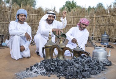 Al Ain, Birleşik Arap Emirlikleri, 16 Kasım 2019: Emirati adamları bir dalleh içinde servis edilen Qahwa adı verilen geleneksel Arap kahvesi hazırlıyorlar.