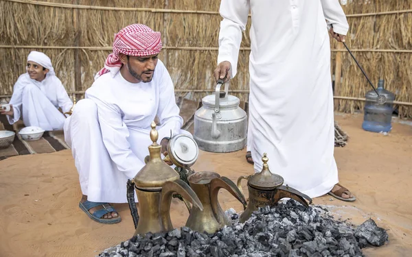 Al Ain, Birleşik Arap Emirlikleri, 16 Kasım 2019: Emirati adamları bir dalleh içinde servis edilen Qahwa adı verilen geleneksel Arap kahvesi hazırlıyorlar.
