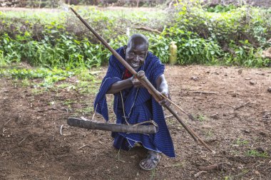 Aynı şekilde, Tanzanya, 7 Haziran 2019: Masai adam yay ve ok yeteneklerini gösteriyor.