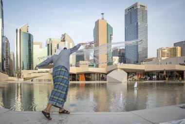 Abu Dabi, Birleşik Arap Emirlikleri, 14 Aralık 2019: balık ağının nasıl atılması gerektiğini gösteren balıkçı