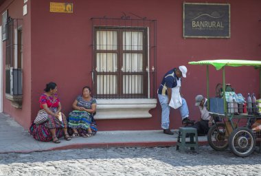 Antigua, Guatemala, 3 Mart 2020: Maya erkekleri ve kadınları sokak köşesinde sohbet ediyorlar