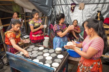 chichicastenango, Guatemala, 27th February 2020: mayan ladies at traditional market making tortillas clipart