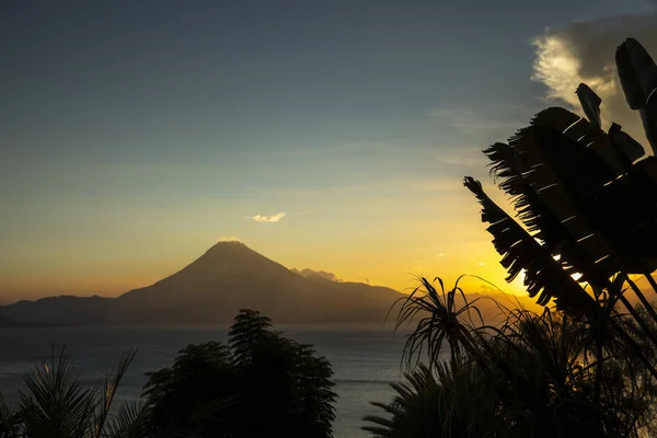 Sunset over lake Atitlan through a tropical garden