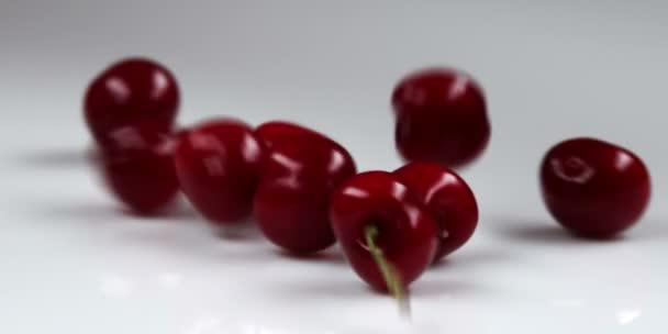 Cerejas vermelhas caindo na mesa — Vídeo de Stock