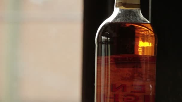 Reflecties in nog whisky fles — Stockvideo