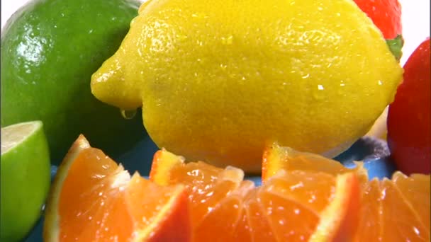 흰색 바탕에 회전 하는 감귤 류의 과일 모듬 — 비디오