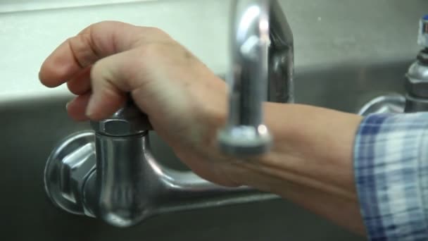Schuss der Hand, die zum Aufdrehen des Warmwasserhahns reicht — Stockvideo