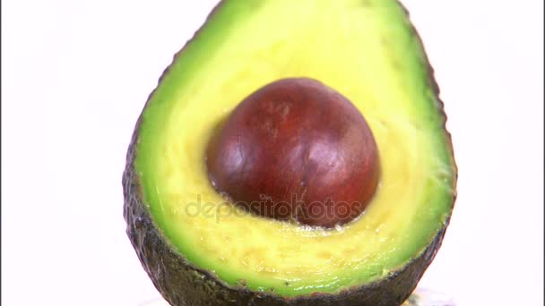 Geschnittene Avocado rotierend auf weißem Hintergrund — Stockvideo