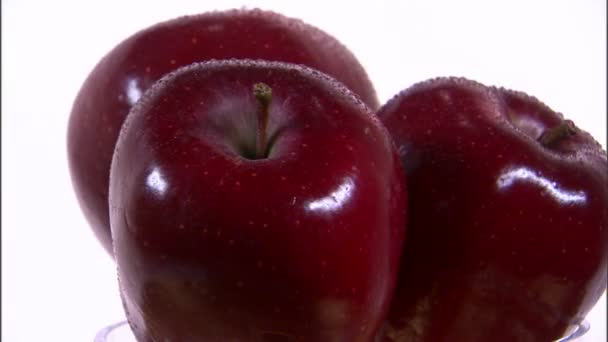 Три яблока вращаются на белом фоне — стоковое видео