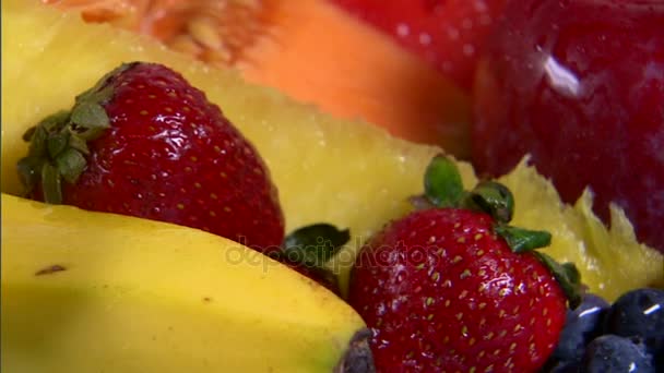 Closeup of assorted fruit rotating on white background — Stock Video