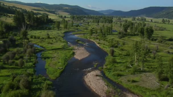 Letecký snímek zelené údolí řeky a ranč v dálce — Stock video