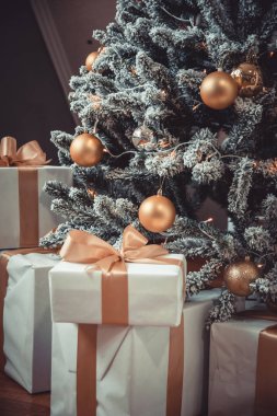 Mutlu noeller. Noel ağacının yanında hediyeler var. Sarı ve altın renkli fotoğraf.