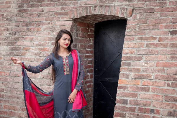 穿着传统印度服装的女孩 萨尔瓦 卡米茨 穿着传统服装的印度姑娘站在房子的入口处 — 图库照片