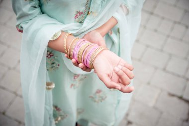 Chudiyan. Kızın ellerinde bilezikler var. Hint kızlarının geleneksel aksesuarları. Geleneksel Hint elbiseli kız, Salwar Kameez.