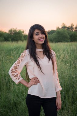 Dışarıdaki Hintli kızın portresi. Pembe günbatımının arka planı.