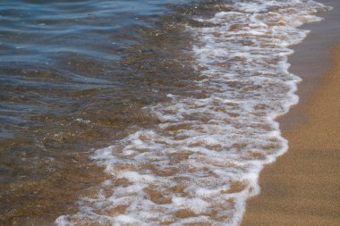 Dalgalar ve volkanik kaynaklı siyah kum. Baia Domizia Sahili, Caserta ili, İtalya