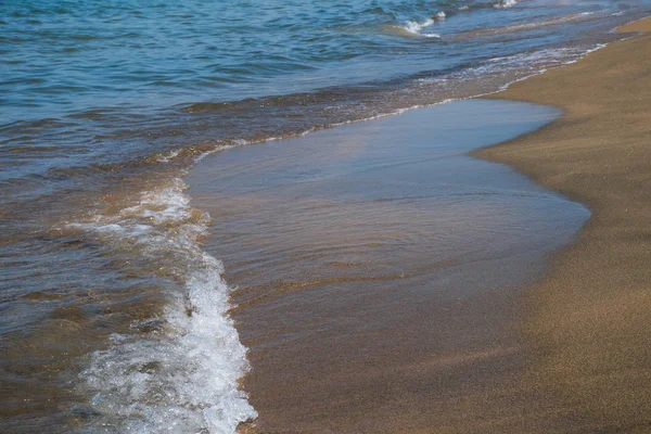 Waves and black sand of volcanic origin. Baia Domizia Coast, Province of Caserta, Italy