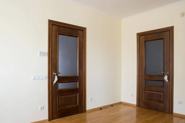 Kapı kapalı ve kapı kolunda beyaz bir tıbbi maske asılı.