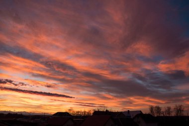 Gün batımı. Akşam gökyüzü, bulutlar farklı parlak renklerle boyanır: mavi, kırmızı, turuncu, mor, pembe, sarı.