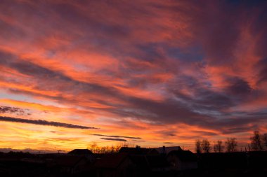 Gün batımı. Akşam gökyüzü, bulutlar farklı parlak renklerle boyanır: mavi, kırmızı, turuncu, mor, pembe, sarı.