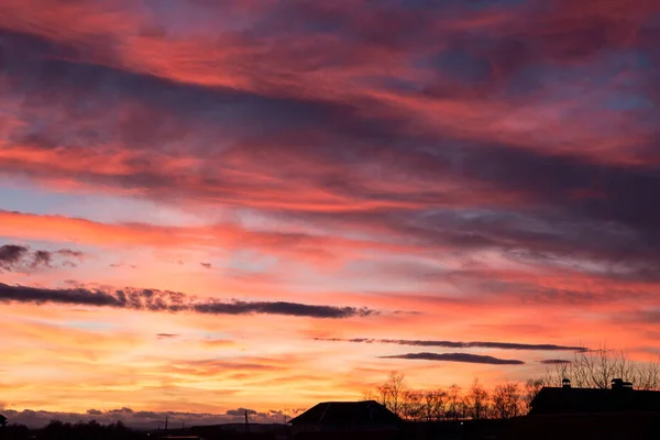 Sunset. Evening sky, clouds are painted in different bright colors: blue, red, orange, purple, pink, yellow.