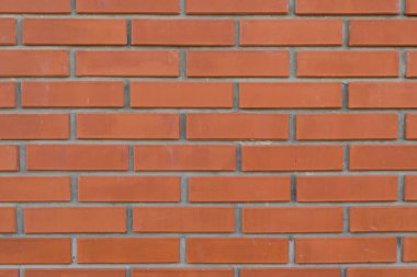 Gri geometrik desenli turuncu arkaplan. Dikdörtgen taşlardan, tuğlalardan, fayanslardan oluşan kırmızı duvar. Tuğla işi