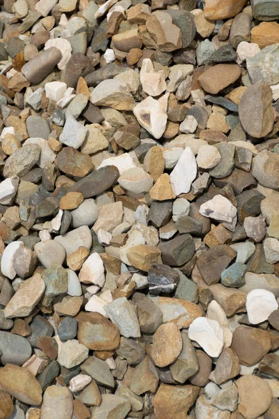 Background with stones of different colors. Stone for construction. Building material. Different textures of pebbles. Rock texture background.