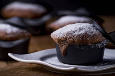 Brownie seti siyah bir güveçte şekerli cam serpiştirilmiş..