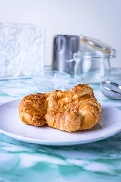Frisches Croissant auf dem Teller mit Backutensilien. — Stockfoto