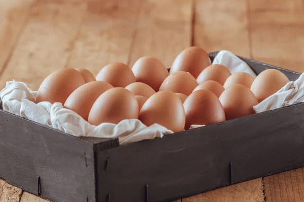 Black wooden box full of fresh eggs.