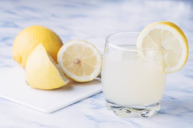 Alttan kesilmiş limonlu bir bardak limonata.