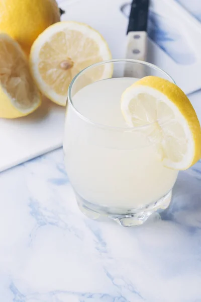 Стакан лимонада с лимонами, вырезанными снизу — стоковое фото