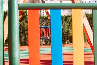 Renklerle dolu bir parkta küçük çocuklar için salıncak.