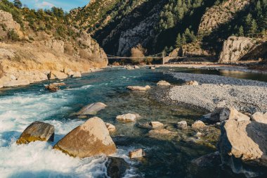 Dağlar ve kayalar arasında zikzak çizen bir nehrin manzarası..
