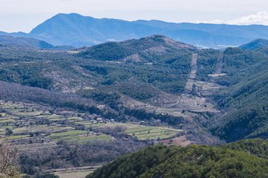 Manzara, arka planında orman olan karlı dağlardan oluşuyordu..
