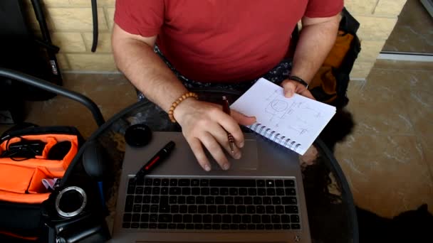カメラを準備しながらノートパソコンで相談するデジタル遊牧民の男 — ストック動画