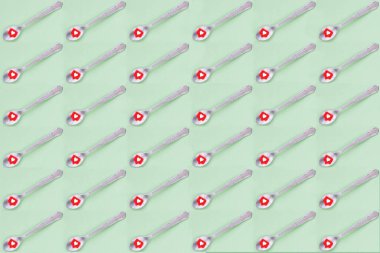 Yeşil arka planda kalp ikonu olan kahve kaşıkları.