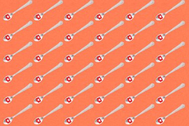 Kırmızı arka planda kalp ikonu olan kahve kaşıkları.