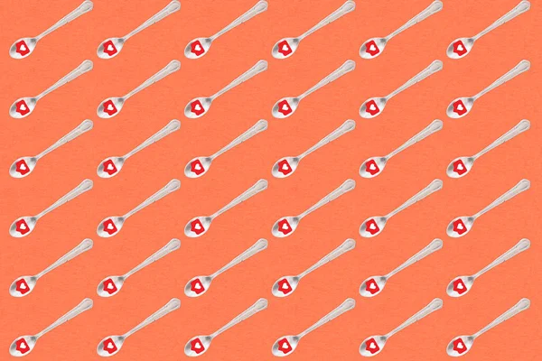 Kırmızı arka planda kalp ikonu olan kahve kaşıkları.