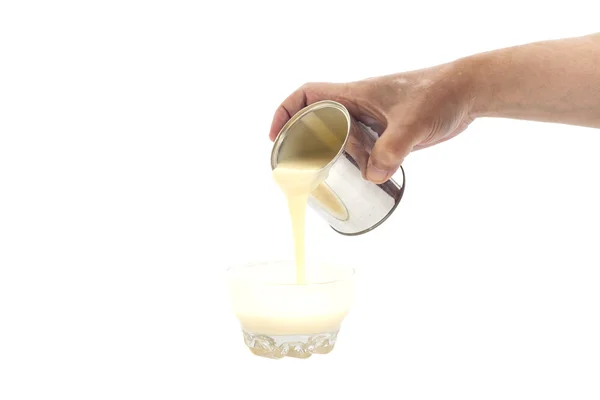 Man hand gieten gecondenseerde melk in een kom — Stockfoto