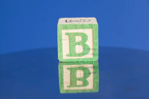 Bloc de lettres en bois B sur fond bleu — Photo