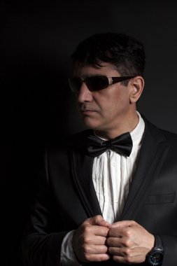 Kelebek güneş gözlüğü ile takım elbiseli bir adam iş elbiseleri