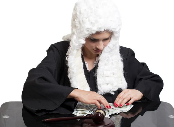 Коррумпированная женщина-судья считает деньги за столом — стоковое фото