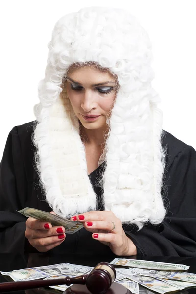 Коррумпированная женщина судья подсчитывает деньги за столом, изолированным на белом — стоковое фото