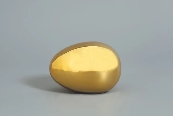 Telur emas diisolasi pada latar belakang abu-abu — Stok Foto