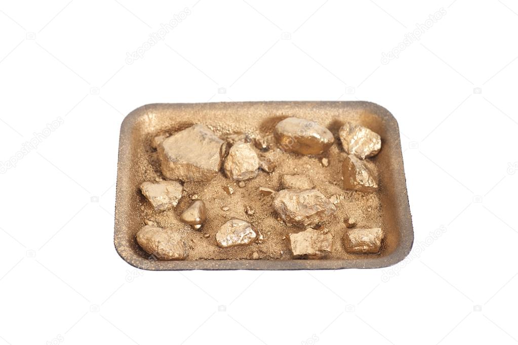 Golden nuggets on grungy wash pan with sand isolated