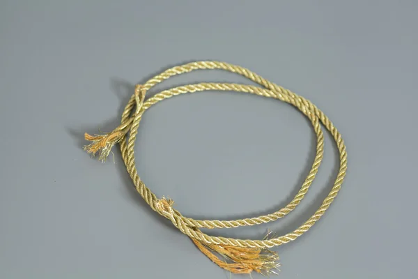 Zlaté lano izolované na šedém pozadí — Stock fotografie