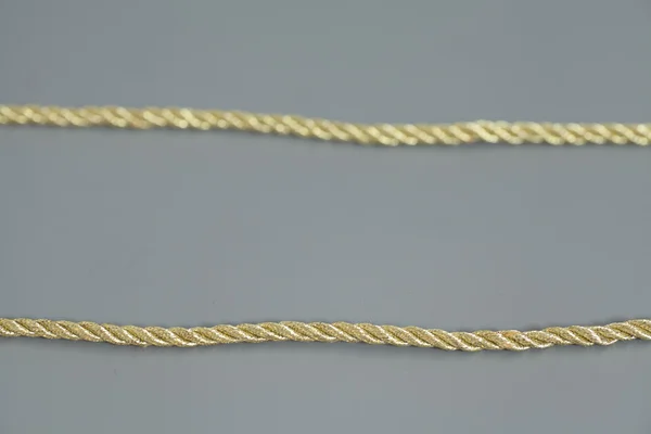 회색 배경에 고립 된 황금 밧줄 — 스톡 사진