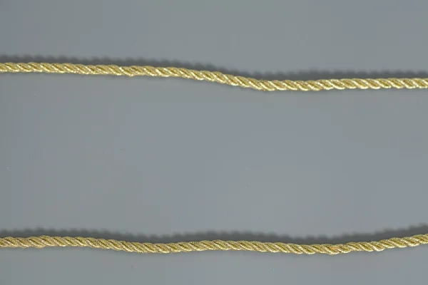 Goldenes Seil isoliert auf grauem Hintergrund — Stockfoto