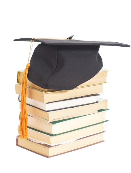 Sombrero de graduación con libros aislados en blanco — Foto de Stock